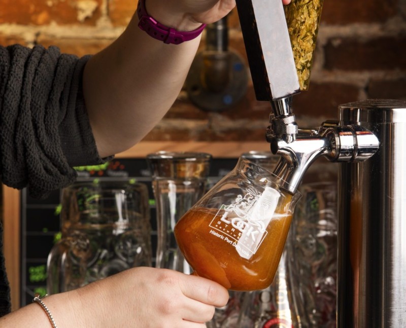 man pouring beer from tap